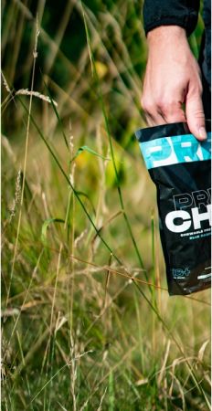 Un homme tient un paquet dans un champ herbeux. - Agence web Prism'