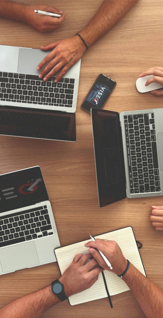 Discussion collaborative autour de plusieurs ordinateurs portables et notes. - Agence web Prism'