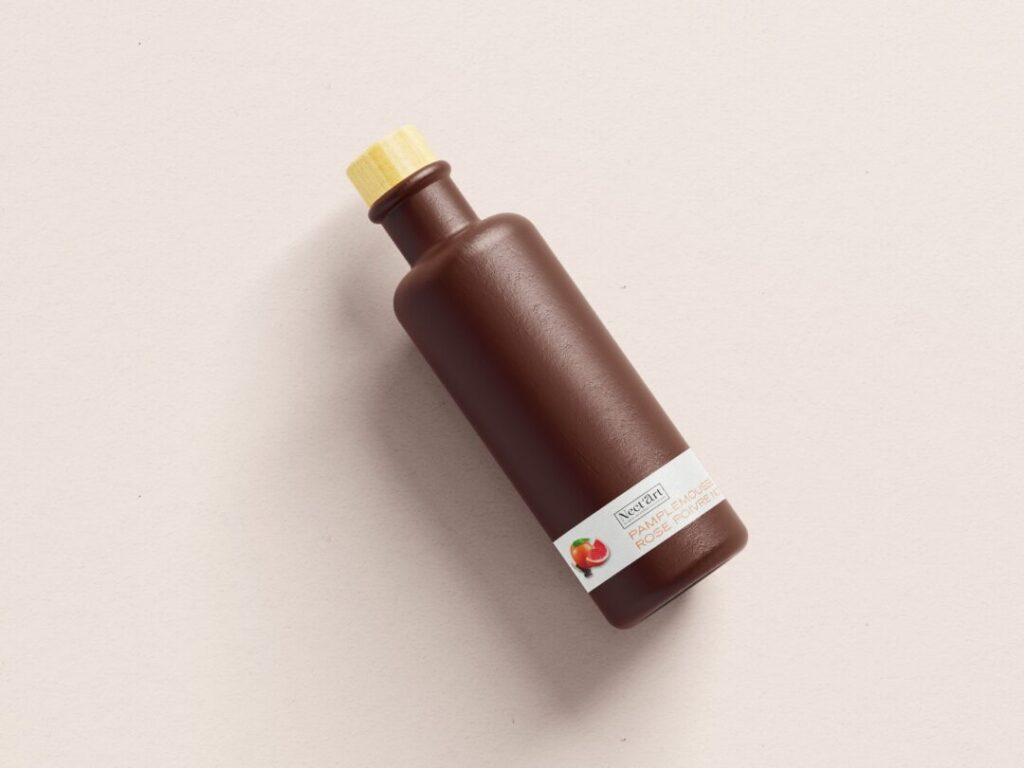 Bouteille marron avec étiquette de produit aromatique au pamplemousse. - Agence web Prism
