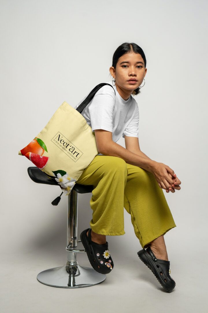 Femme assise, tenu décontractée, sac éthique, look moderne. - Agence web Prism