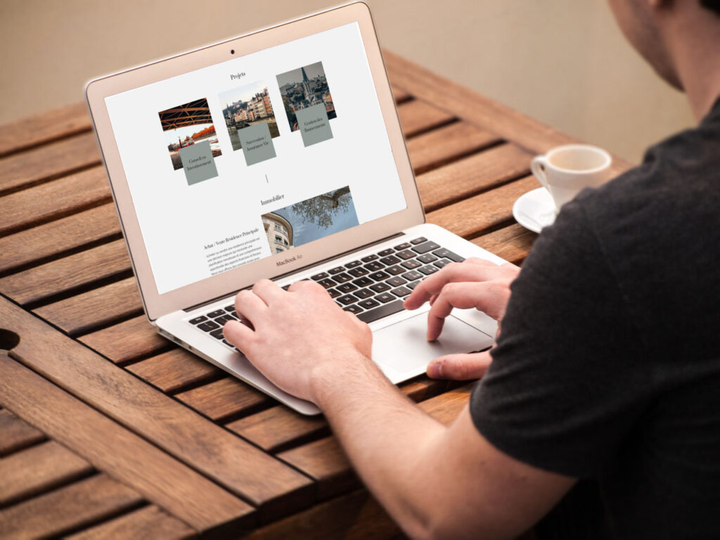 Personne utilisant un ordinateur portable sur une table en bois.
